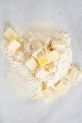 cold butter cube with all-purpose flour in preparation to make puff pastry dough.