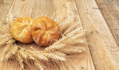Fresh bread and wheat on a wooden table  - 527660156