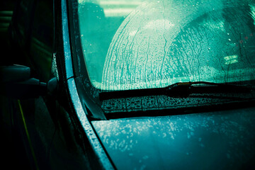 Raindrops run down the windshield of a passenger car, which are removed by the wipers. Bad weather....