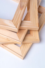 A stack of wooden stretchers for stretching the canvas lies on a white background. Vertical photo