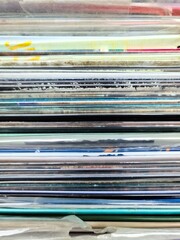 Numerous vintage signs and vinyl records in a box seen from above.