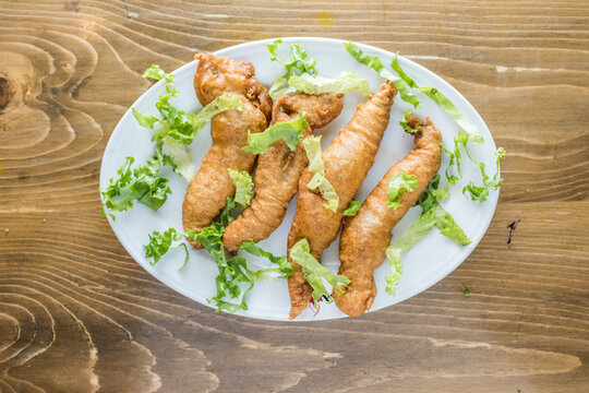 Loitta Fried fish with onion, pepper and salad served in a dish isolated on wooden table top view of indian and bangladesh food