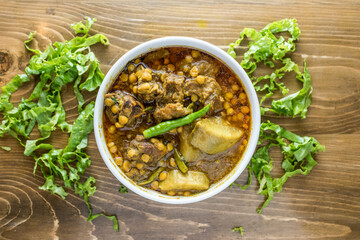 Chonar Daal or dal chana chicken gosht with onion, pepper and salad served in a dish isolated on wooden table top view of indian and bangladesh food