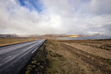 Fototapeta na wymiar nass glänzende Straße durch island Richtung Ólafsvík