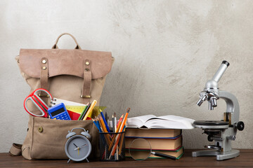 Back to school - books and school backpack on the desk in the auditorium, Education concept.