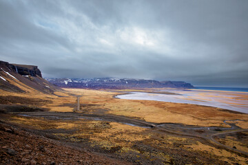 stimmungsvolle Küste mit goldenem strand und Bergkette in island
