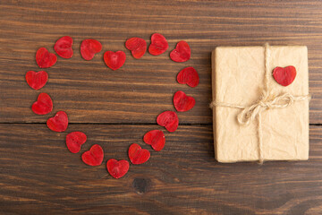 Valentine's Day greetings concept. Little red wooden crafted hearts and gift boxes on the wooden...