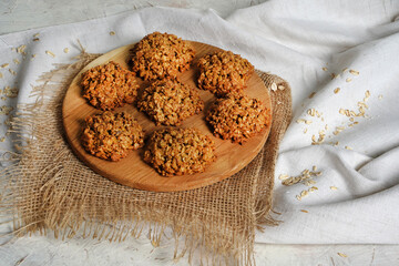 Oatmeal cookies close up view. Stack of homemade delicious rolled oats cookies on table napkin, oat...