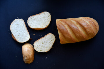 Fresh loaf on a black background. Delicious bread for butter close-up.