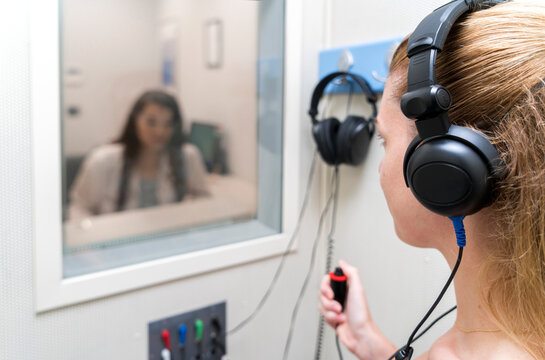 Audiologist woman doing the hearing exam to a mixed race woman patient using an audiometer in a special audio room. Audiometric testing. Hearing loss treatment.
