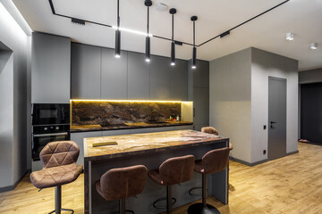 Modern luxury apartment with a free layout in a loft style in gray and dark colors. Stylish kitchen...