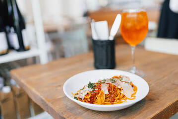 Traditional italian spaghetti bolognese and glass of Spritz Aperol. Concept of italian cuisine. Pasta with meat and tomato sauce