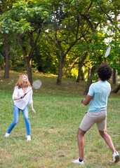 Young mixed race couple playing badminton on a summer meadow
