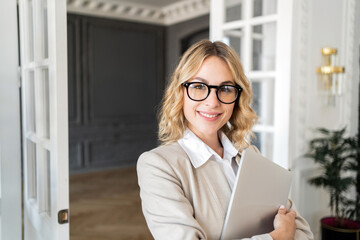 A confident business woman financier in a stylish suit works in an office