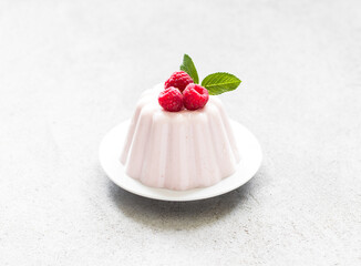 Raspberry Panna Cotta on a plate. Light gray background