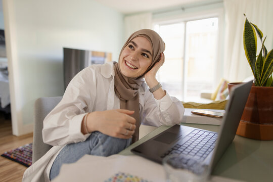 Portrait Happy Young Woman In Hijab Working From Home At Laptop