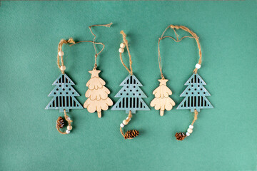 wooden figures of Christmas trees on a green background, a place to copy, Christmas decor