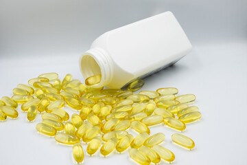 Jar with omega-3 capsules isolated on white background. Omega 3 capsules poured out of the box close-up