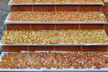 Cut apple slices are placed on stairs for drying in the open air under the sun. Selective focus.