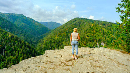 A woman observes the beautiful nature. A view of the most beautiful mountains in a panoramic scene....