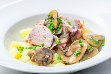 veal roll in bacon with mushroom sauce and potatoes