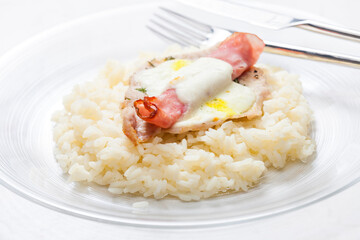 poultry meat baked with ham and cheese served with rice