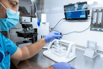 Embryologist adding sperm to egg in laboratory of reproductive clinic. in vitro fertilization, egg...