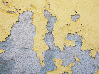 Peeling yellow paint on concrete wall texture