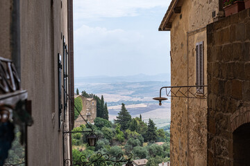 View to impressive ancient cobblestone street with ancient stone buildings and with blue sky and mountain landscape in the background