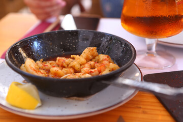 fried shrimps with lemon slice, garlic sauce aioli and tomato ketchup frying pan close up photo