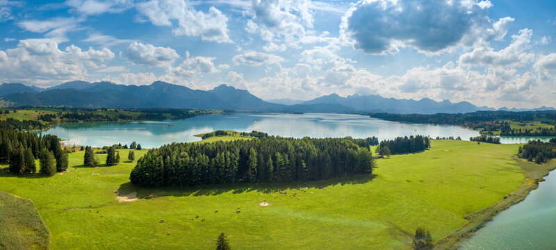 Aerial drone view of Forggensee close to Füssen during summer with the Alps in the background © Tobias