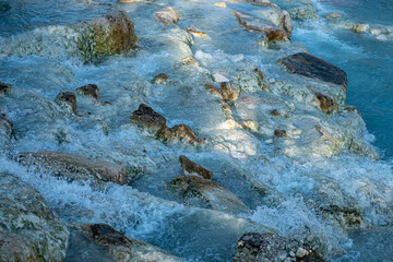 Hot thermal springs in Tuscany with turquoise water, rock, on a sunny summer day, background for quotes, place for text. 