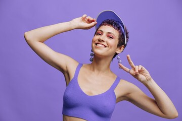 Fashion woman in bright purple sportswear portrait smiling and looking at camera on purple background and smiling