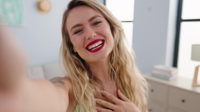 Young beautiful hispanic woman having video call standing at home