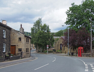 a view of the old village centre of mytholmroyd in west yorkshire with old stone buildings surrounded by pennine countryside