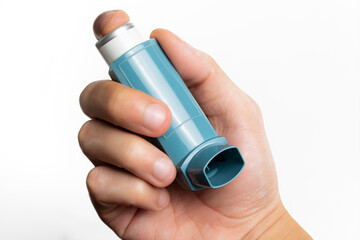 Holding an asthma inhaler on white background with copy space