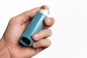 Hand holding an asthma inhaler on white background with copy space