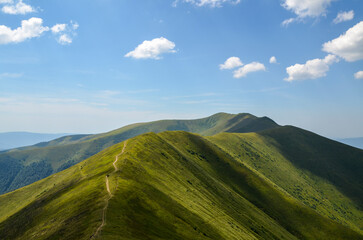 The picturesque landscape of the Borzhava mountain range with steep slopes covered with green grass. Carpathian Mountains, Ukraine