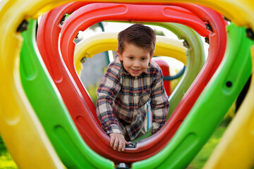 Niño rubio latino feliz alegre jugando divertido cruzando un área de juegos en el parque al...