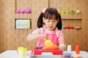 young girl pretend playing food preparing at home