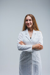 modern cheerful doctor in a white coat on a gray background. Woman doctor with a smile on her face
