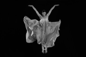 Fototapeta premium dancer in a jump on a black background, woman falling, woman angel