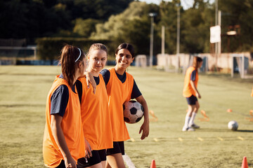 Fototapeta premium Happy female soccer players talk during sports training at stadium.