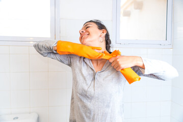 young latina woman, happy while cleaning the bathroom