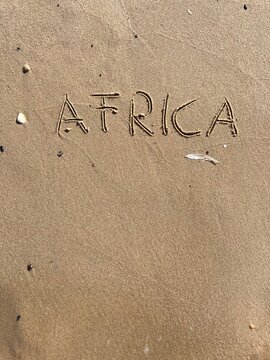 on the beach is carved with letters in the smooth sand the writing Africa