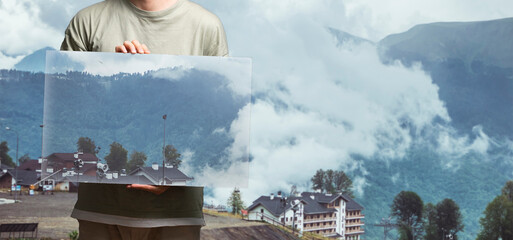 person holding a square frame with a backround painting, surreal creative concept
