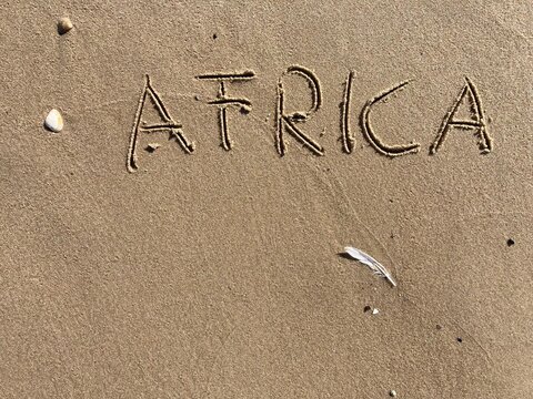 on the beach is carved with letters in the smooth sand the writing Africa
