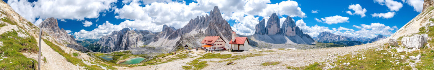 Fototapeta na wymiar Dreizinnenhütte with small chapel in front of the Tre Cime (Drei Zinnen) and Monte Paterno (Paternkofel) panorama in the Dolomite Alps of South Tyrol in Italy