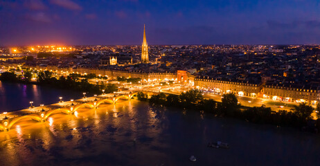 Aerial view of Bordeaux cityscape on banks of Garonne river and Pont de pierre at night
