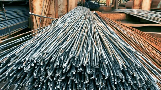 Iron rebars or a metal bars lie in an outside storage of a rolling mill